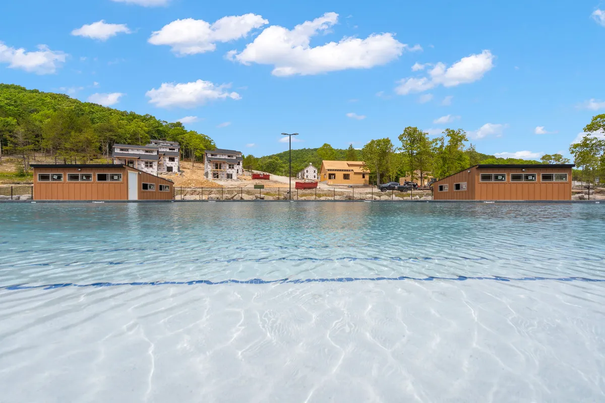 A peaceful lakeside setting with waterfront cabins, clear water gently reflecting the sky, and a distant landscape background. The image showcases the tranquility and beauty of Table Rock Lake, inviting viewers to imagine boating, fishing, swimming, or simply relaxing by the water.